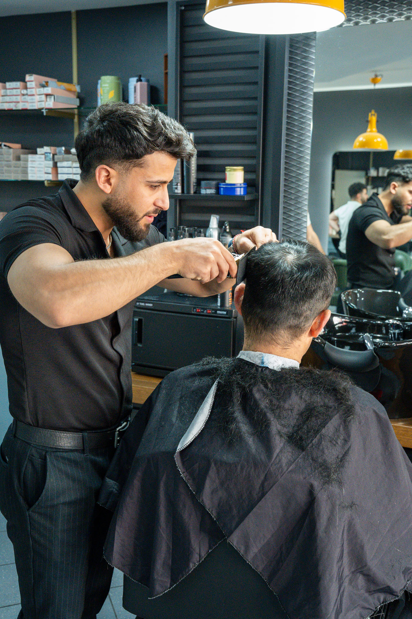 Friseur beim präzisen Schneiden im Aachener Salon